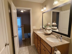 A bathroom with two sinks, a large mirror, and a towel rack.