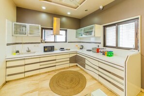 Una cocina moderna con microondas, hervidor y varios electrodomésticos en la encimera.