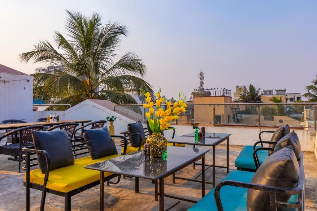 A rooftop terrace with outdoor seating, a decorative vase, and a view of the cityscape.