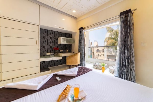 Une chambre d’hôtel avec un lit, un bureau et une fenêtre avec des rideaux.