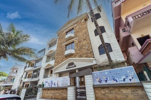 A multi-story residential building with balconies, a stone facade, and a signboard. - Coliwo Deux Hostel - Chandan Nagar (Pune)