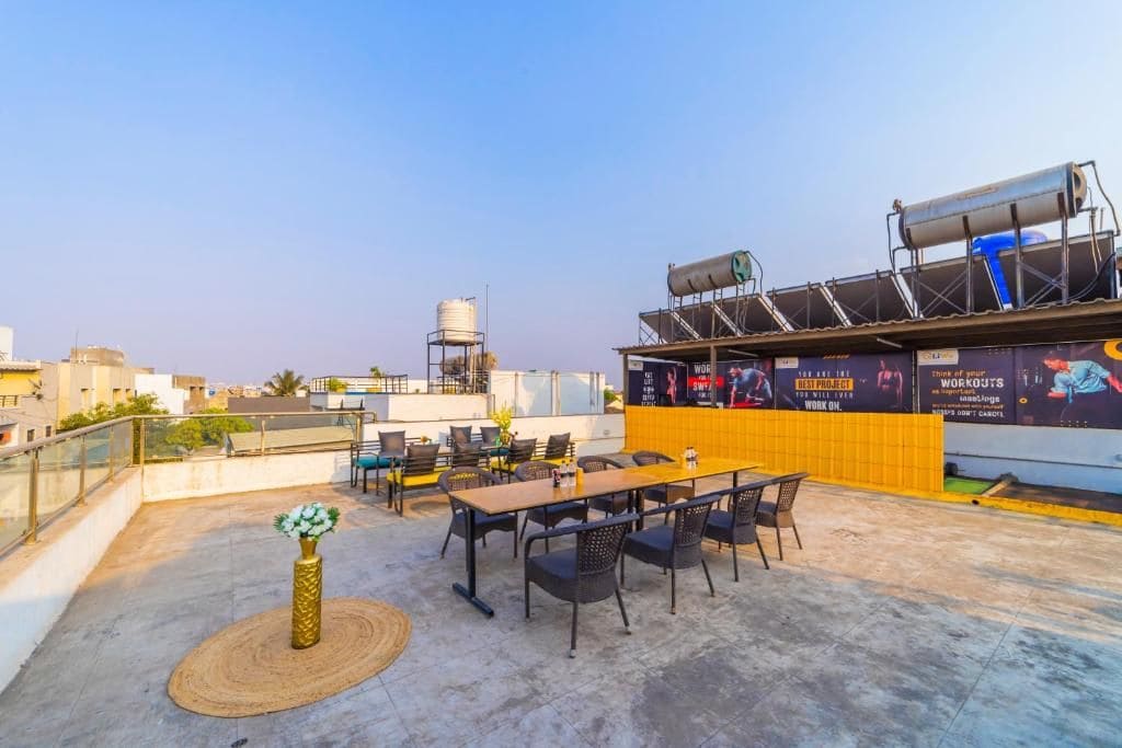 A rooftop terrace with outdoor seating, a water tank, and a large advertisement.