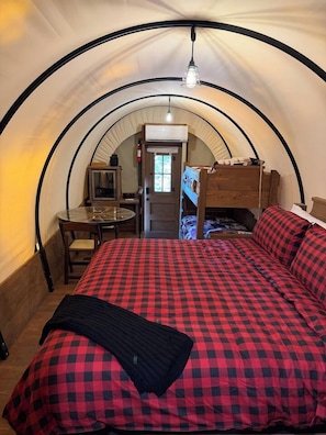 Ein Zeltraum mit einem Bett, einem Tisch und einem Stuhl.