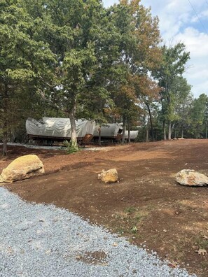 A campsite with covered vehicles and large rocks.