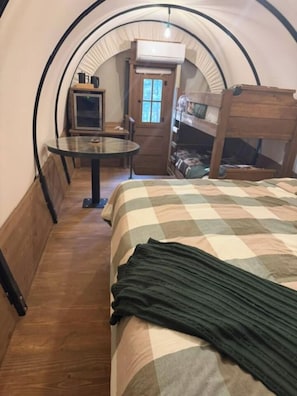 Ein gemütliches Zimmer mit einem Etagenbett, einem kleinen Tisch und einem Fenster.