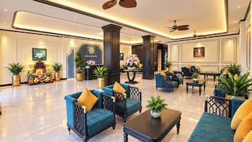A spacious lobby with seating arrangements, a reception desk, and decorative elements.
