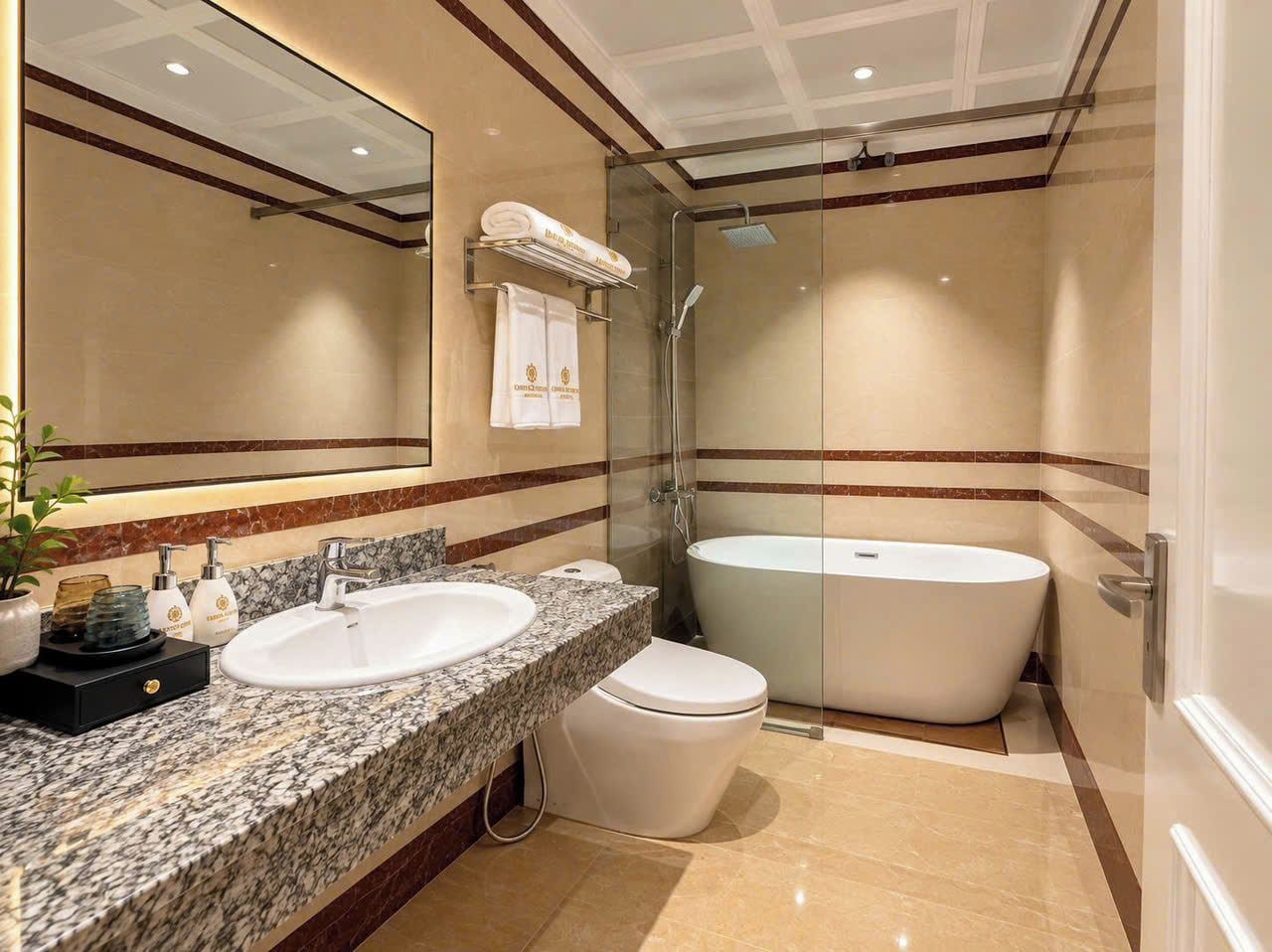 A modern bathroom with a large mirror, two sinks, a toilet, and a freestanding bathtub.