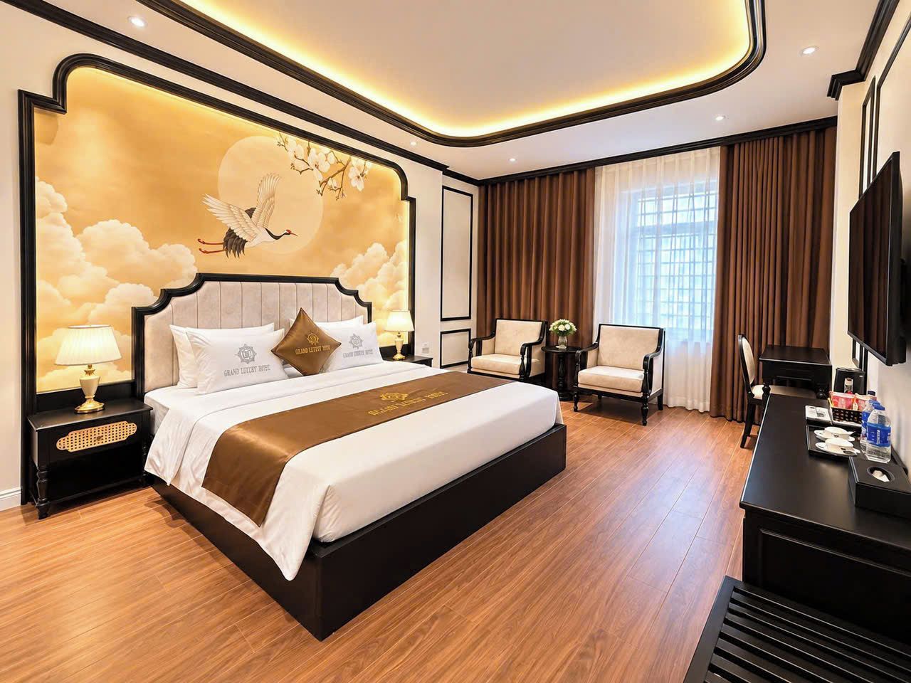 A hotel room with a large bed, a desk, a chair, a TV, and a wall with a decorative mural.