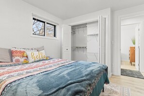 Ein Schlafzimmer mit Bett, Schrank und Blick ins Freie.
