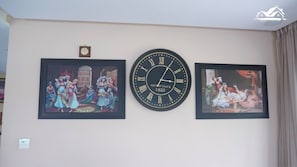 A wall with two framed paintings and a vintage clock. - Bens White House (Laayoune Ain Tizgha)