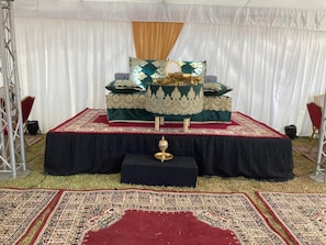 A stage with a black table, a golden bowl, and a red carpet. - Bens White House (Laayoune Ain Tizgha)