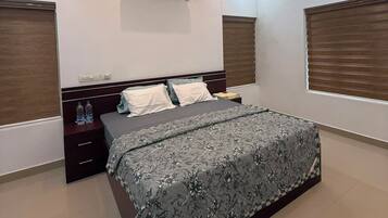 A modern bedroom with a central bed, a ceiling fan, and an air conditioning unit.