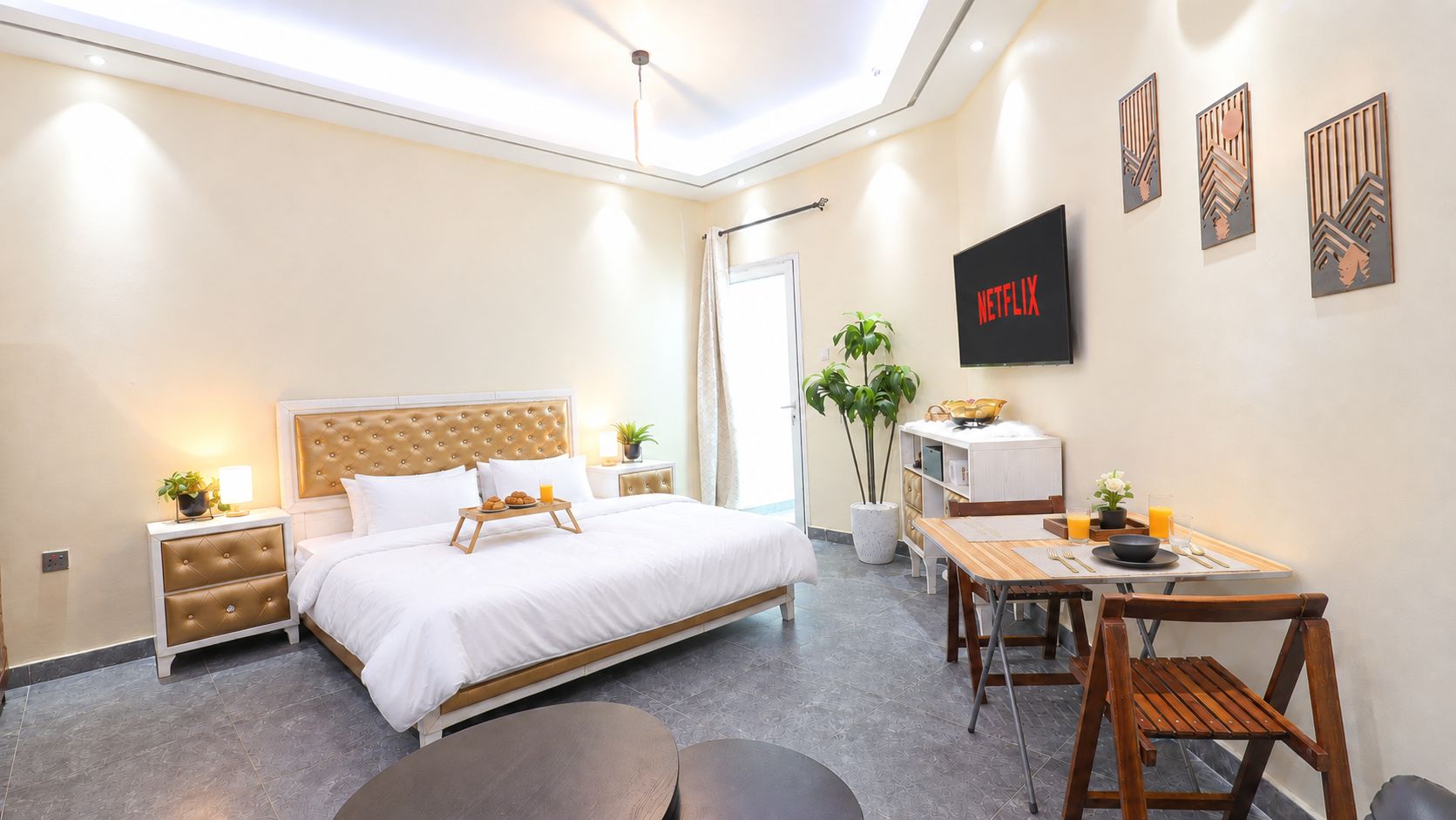 A modern hotel room with a bed, bedside tables, a desk, and a chair.
