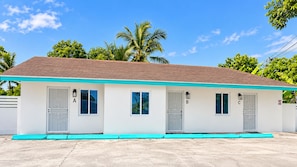 A single-story building with a flat roof, three doors, and a small porch area. - Aqua Suites (Nassau)