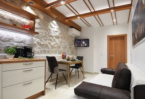 Um espaço compacto com cozinha compacta, área de refeições e espaço para sentar.