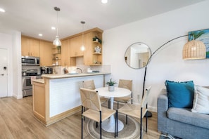 A modern kitchen with wooden cabinets, a central island, and stainless steel appliances. - Living the Resort Life - Pool (Carlsbad)
