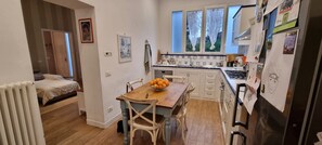 A compact kitchen with a dining table, chairs, and a fruit bowl. - Apartment near the beach (Marina di Pietrasanta)