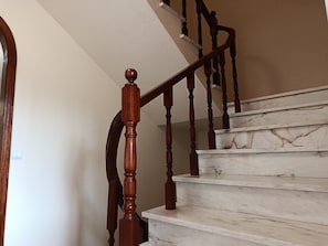 A staircase with wooden balusters and marble steps.