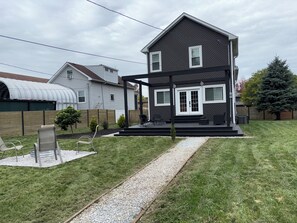 A two-story house with a covered porch and a small garden area. - Oak and Onyx Spacious 4-bedroom house in wonderful Beverly Chicago with AC (Chicago)