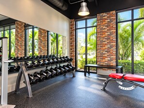 A gym with a brick wall, large windows, and exercise equipment. - Luxurious Retreat 3Beds/2Baths with Club Access (Davenport)