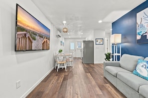 Een moderne woonkamer met een grijze bank en een blauwe accentmuur.