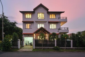 A multi-story residential building with a balcony on the upper floor, a gated entrance, and a driveway leading to a parked motorcycle. - 6BR Pool Villa with Karaoke & Games Room, Thảo Điền, Sleeps 14 (Thành phố Hồ Chí Minh)