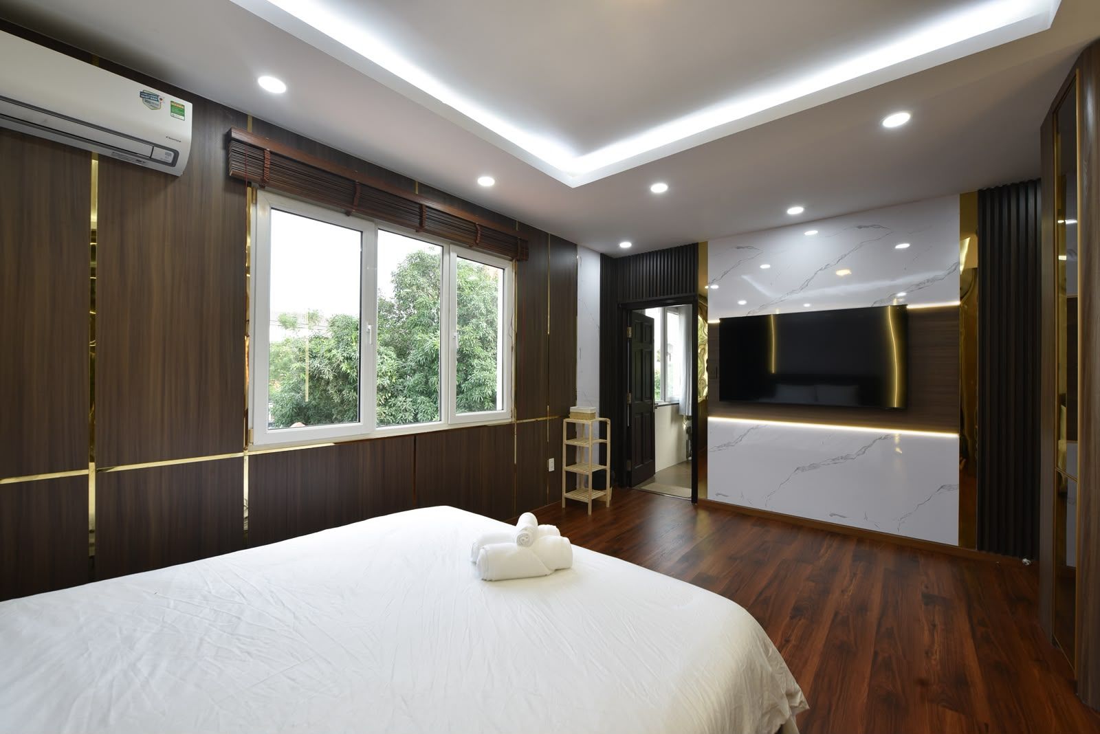 Una camera d'albergo con un letto, una televisione e vista sul verde.