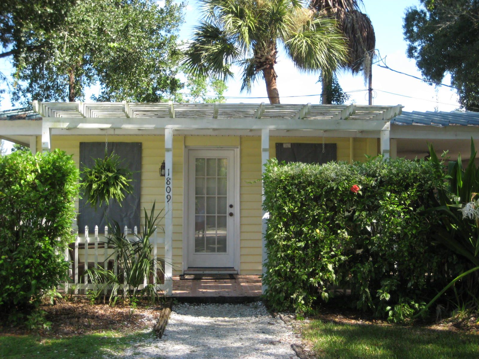 A yellow house with a white door and a small porch.