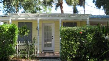 A yellow house with a white door and a small porch.
