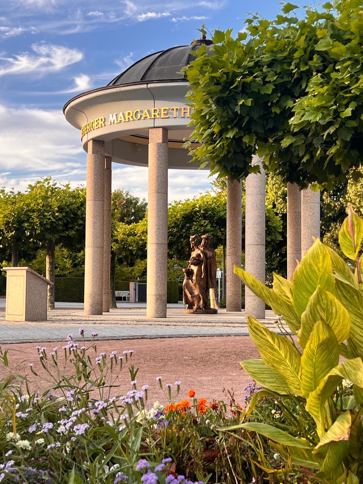 Ein Pavillon mit der Aufschrift 'BERGER MARGARETH' und einer Statue einer Frau und eines Kindes.