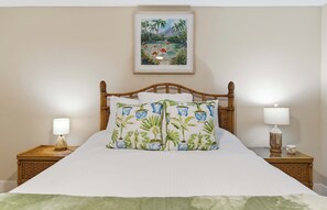 A bed with a wooden headboard, two bedside lamps, and a framed tropical painting above it. - Steps to Siesta Beach  Remodeled 2BR  Pool (Siesta Key)