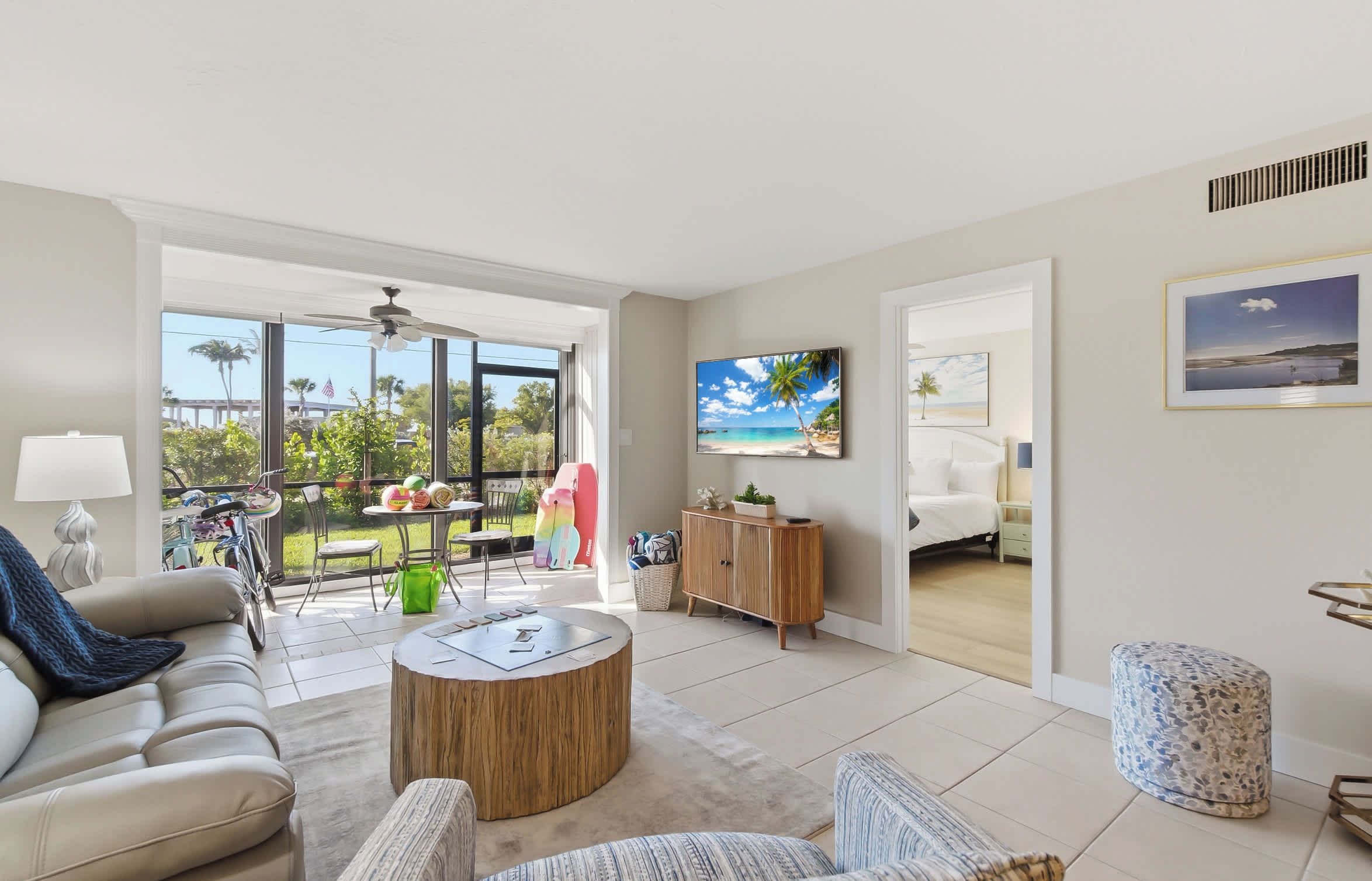 A spacious living area with a sofa, coffee table, and a view of the outdoors through large windows.