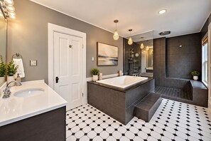 Un bagno moderno con una vasca da bagno ampia, una cabina doccia separata e un mobile lavabo con lavandino.