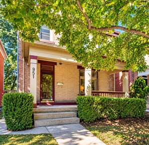 A two-story house with a brick facade, a front door, and a mailbox. - Large Short North House - Hot tub, FirePit, Private Parking, Best Location (Columbus)