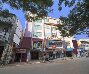 A multi-story building with signage for Daksha Neet UG and Oyo Books. - Classic Nettoor (Adityapur)