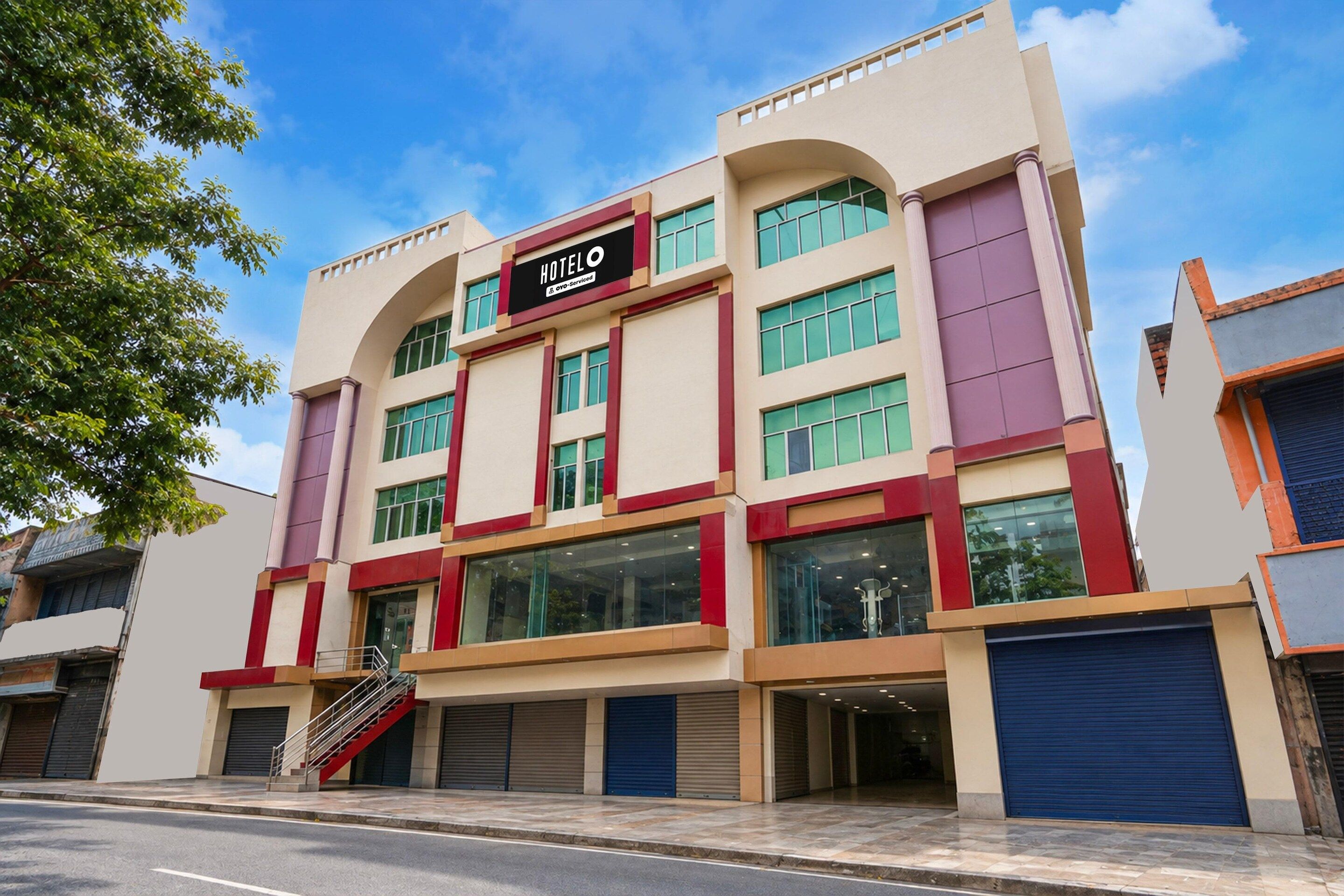 A multi-story hotel with a prominent 'HOTEL' sign, multiple windows, and a staircase leading to the entrance.