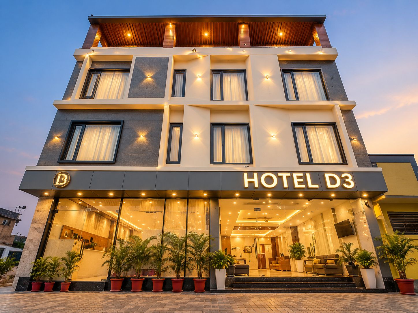 Un hôtel à plusieurs étages, doté d’une façade moderne, de grandes fenêtres et d’une entrée bien éclairée.