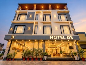A multi-story hotel with a modern facade, large windows, and a well-lit entrance. - Hotel D3 And Rooftop Mansarovar Jaipur (Jaipur)