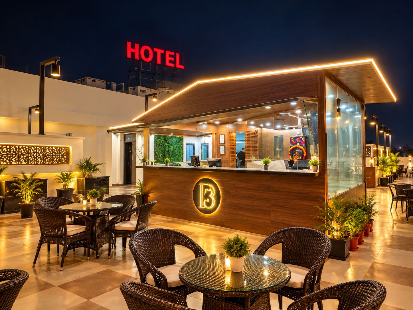 Un espace d’accueil d’hôtel avec un comptoir, des sièges et une vue sur le paysage urbain illuminé la nuit.