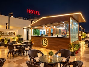 A hotel reception area with a counter, seating, and a view of the cityscape at night. - Hotel D3 And Rooftop Mansarovar Jaipur (Jaipur)