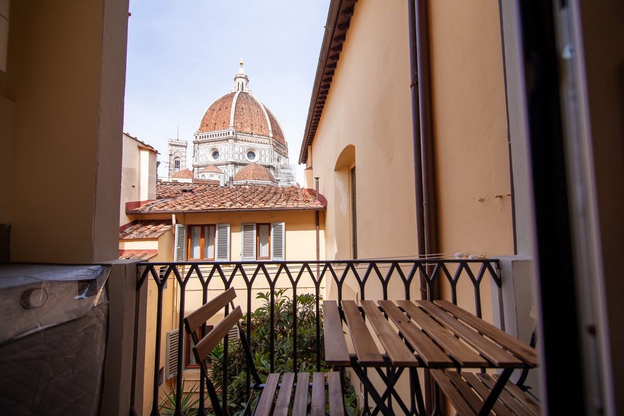 A balcony with a view of a historic building with a dome.