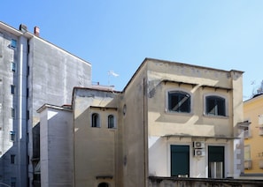 A building with a flat facade, two visible windows with shutters, and a small balcony. - Maureen Holiday House (napoli)