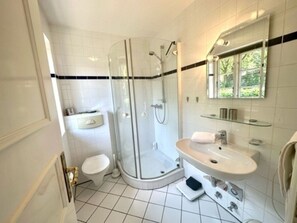 A modern bathroom with a glass-enclosed shower, a white sink, and a toilet. - At Museum Apt. 3 (Alkersum)