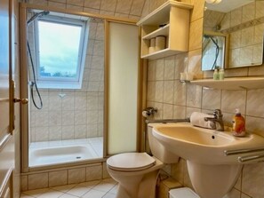 A bathroom with a bathtub, toilet, and sink. - Hansen Grevelingstieg 16 (Nieblum)