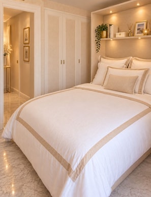 A bedroom with a large bed, a wardrobe, a bedside table, and a shelf with decorative items. - Vrbo Property (Cannes)