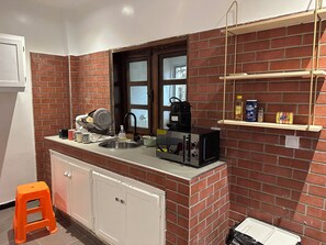 A compact kitchen with a sink, a coffee machine, and a window. - Vrbo Property (Dakar)