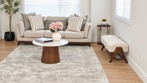 A living room with a beige sofa, a round coffee table, a small side table, and a bench. - 3 BR Home-7 minutes from West Edmonton Mall (Edmonton)