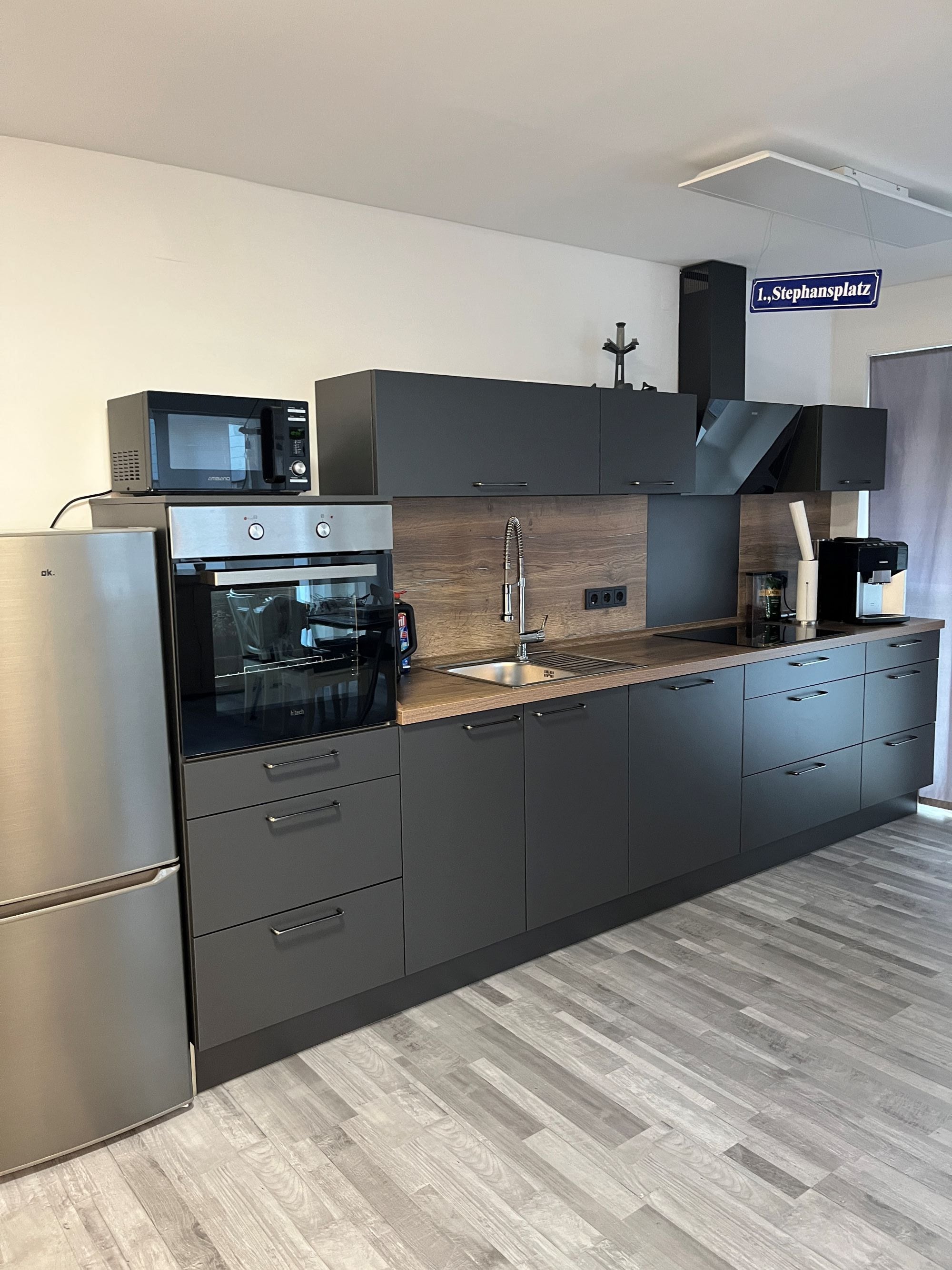 Eine moderne Küche mit Einbauofen, Mikrowelle und Kaffeemaschine.