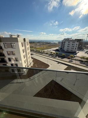 A view of a modern building complex with multiple floors, a parking area, and a clear sky. - Cozy clean & minimalistic apartment near Airport, with balcony & view! (Chișinău)