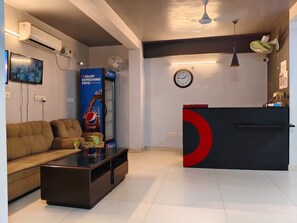 Una sala moderna con un sofá, una mesa de centro y un anuncio de Pepsi.